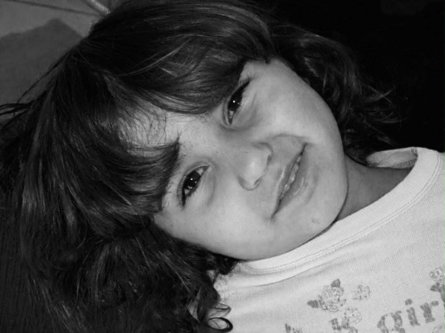 Giovanna ainda criança, sorrindo, em foto preto e branco